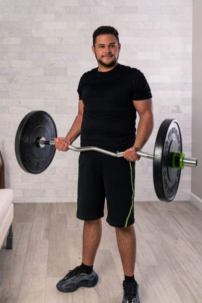 Gabriel Moreta holding a bar with weights on both ends